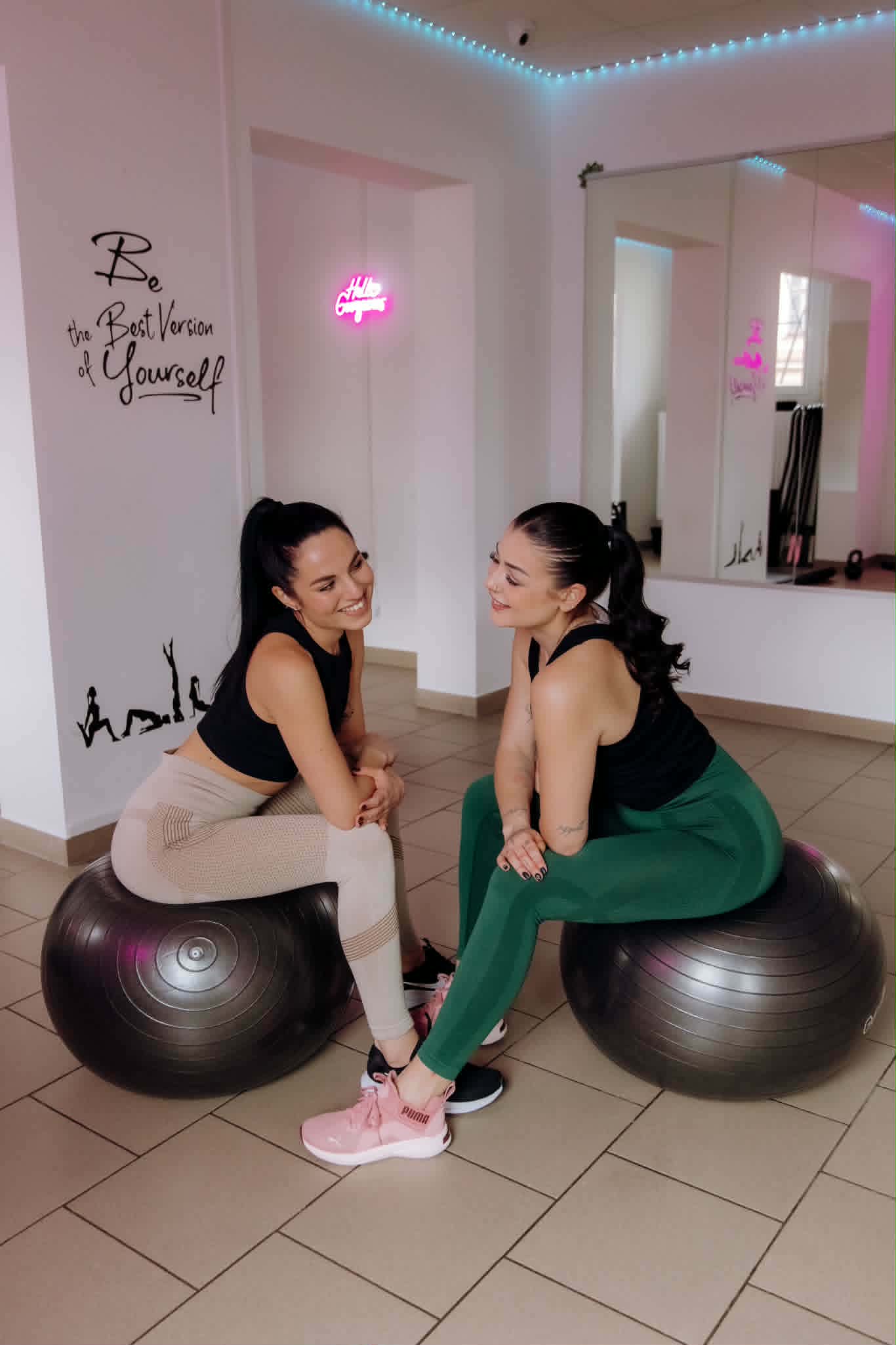 Két vendég beszélget a Harmony Fitness Studio világos edzőtermében